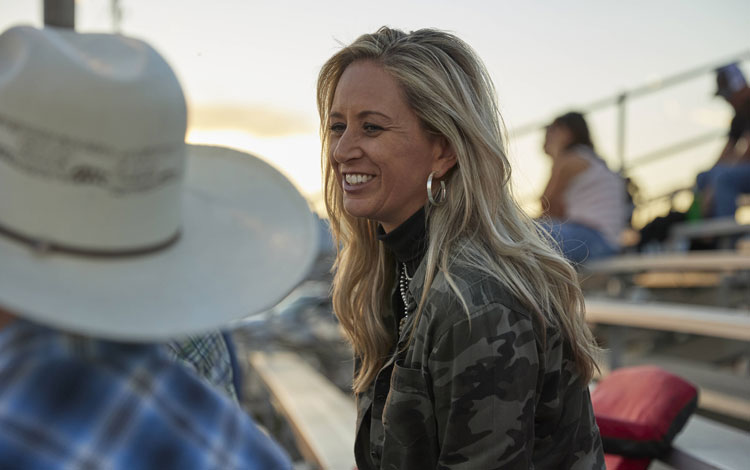 Shali talking to a friend off camera laughing and smiling.